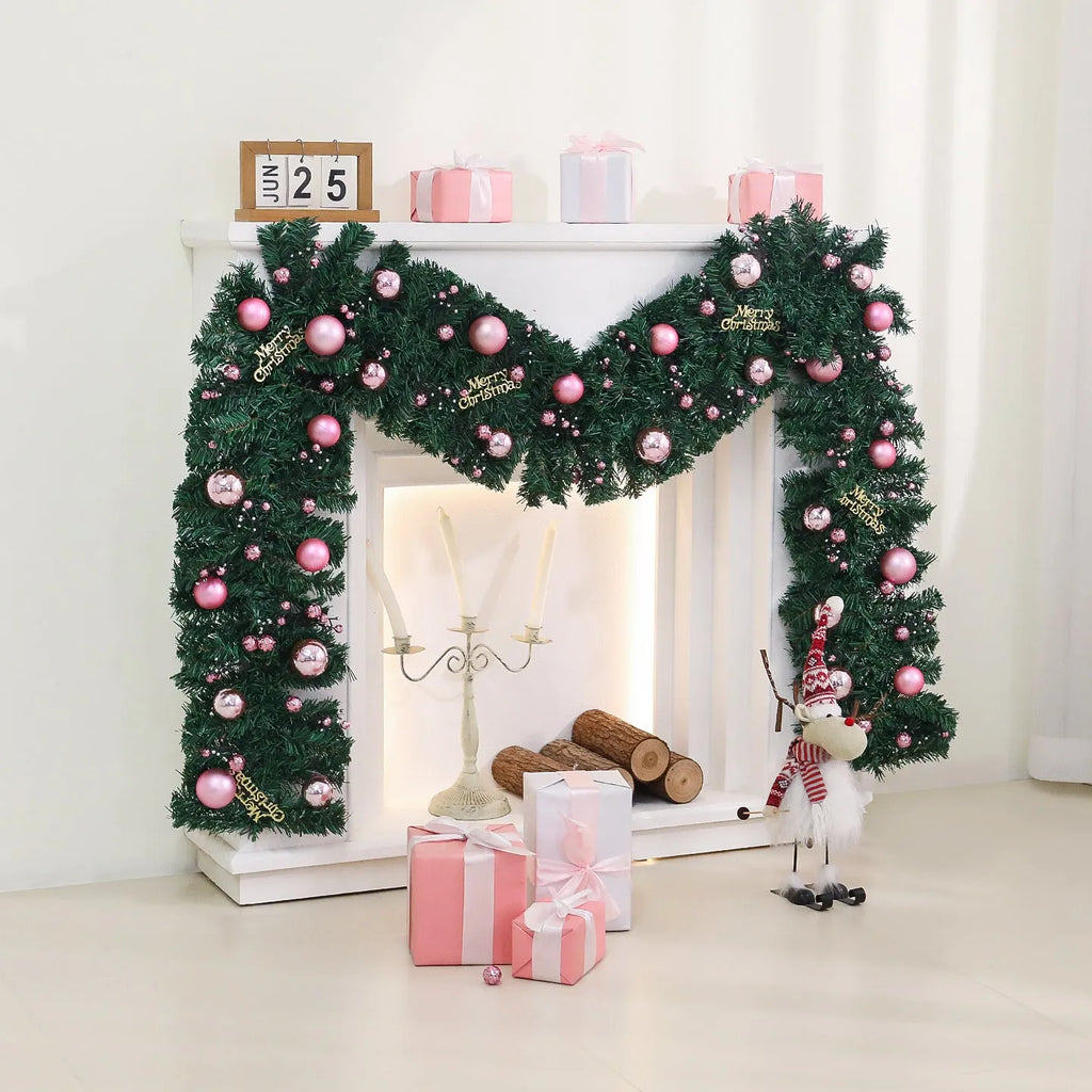 Pink artificial rattan Christmas garland with small fruit and LED lights draped over a banister