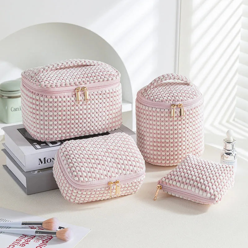 Set of four cube-shaped pink flannelette makeup bags with zips, one showing a removable interior divider and a metal hook.