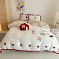Cartoon pattern winter bedding four-piece set including bed sheet, duvet cover, and pillowcases on a bed.