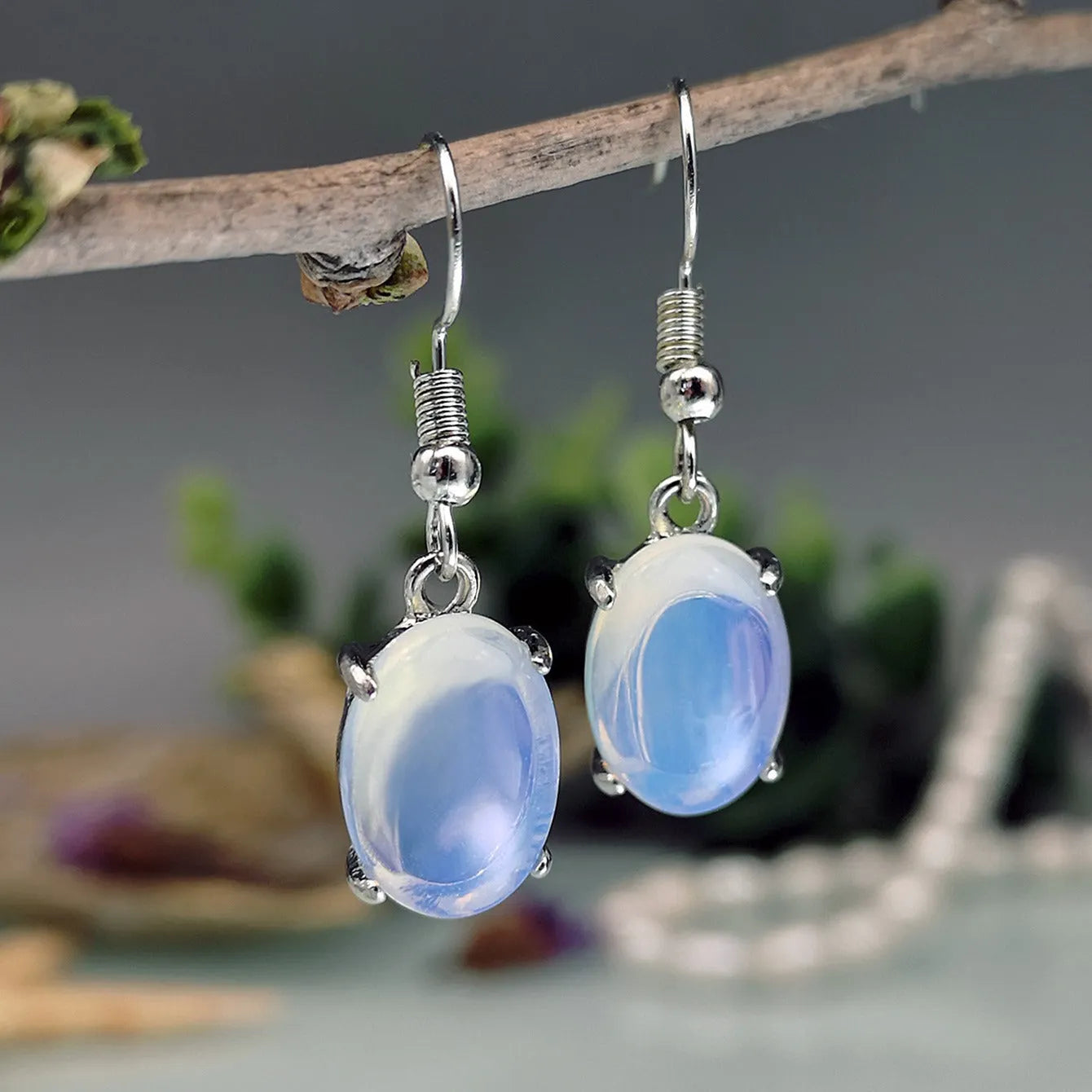 Pair of retro-style drop earrings with a moonlight opal colour and cross detail on an alloy base.