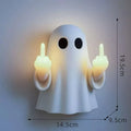 White cute ghost statue plastic night lamp for Halloween decoration on a dark surface.
