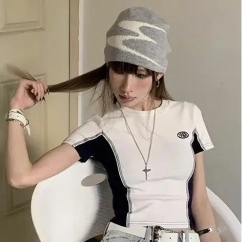 A knitted acrylic beanie hat in black, shown on a model, for autumn and winter wear.