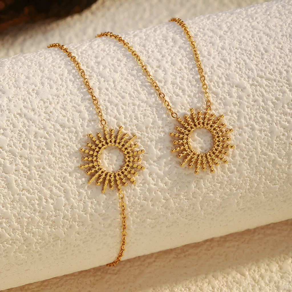 Gold-coloured SUNFLOWER Series necklace and bracelet set with chain links on a white background.
