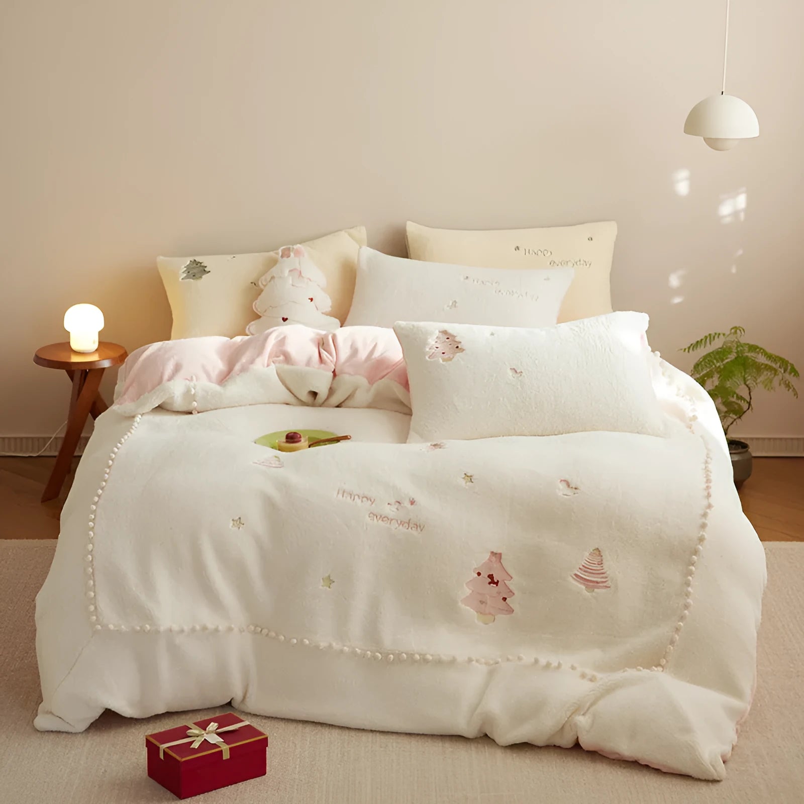 Winter milk fibre bedding four-piece set with green Christmas tree pattern on a bed.
