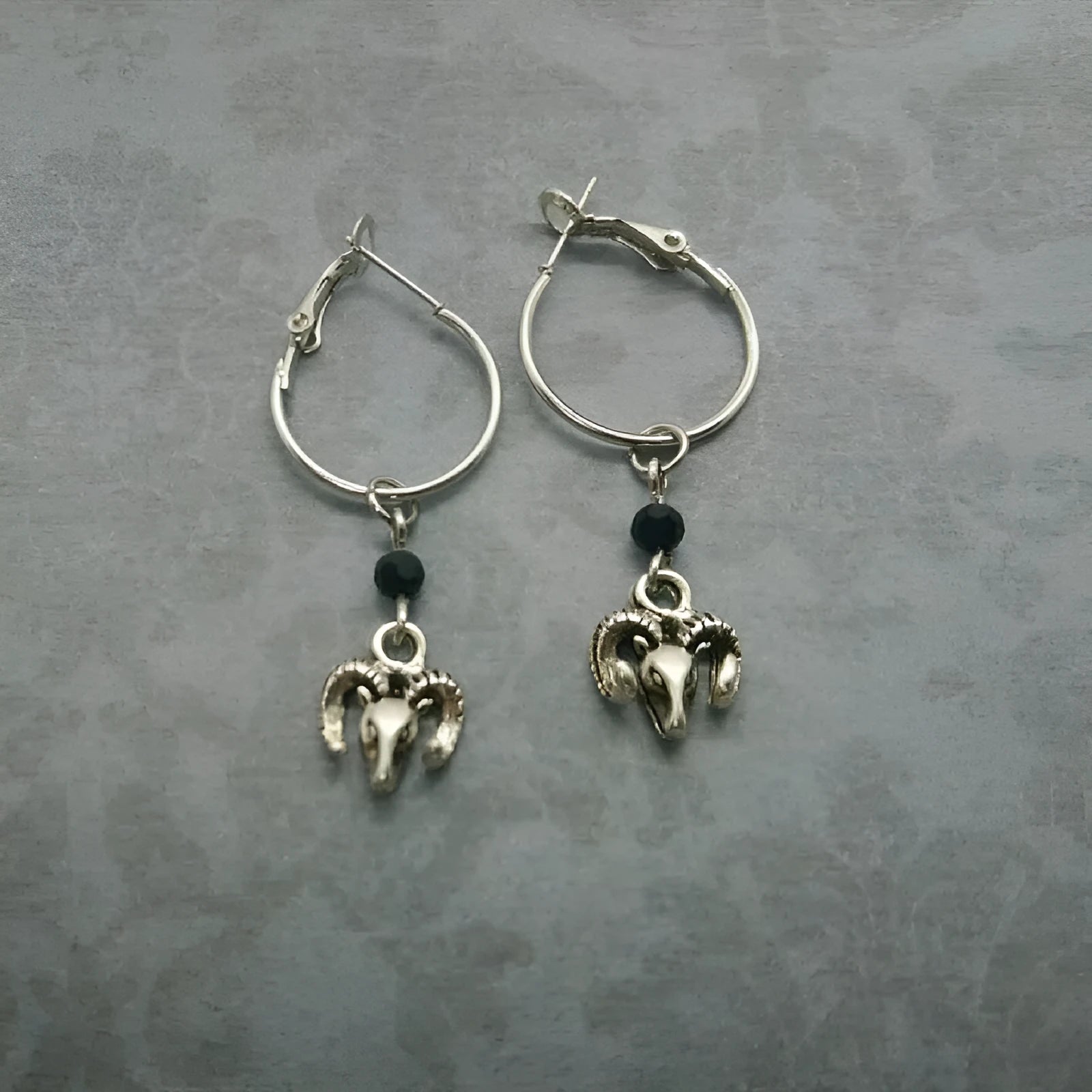 A pair of silver-coloured alloy round ring earrings for women on a white background.