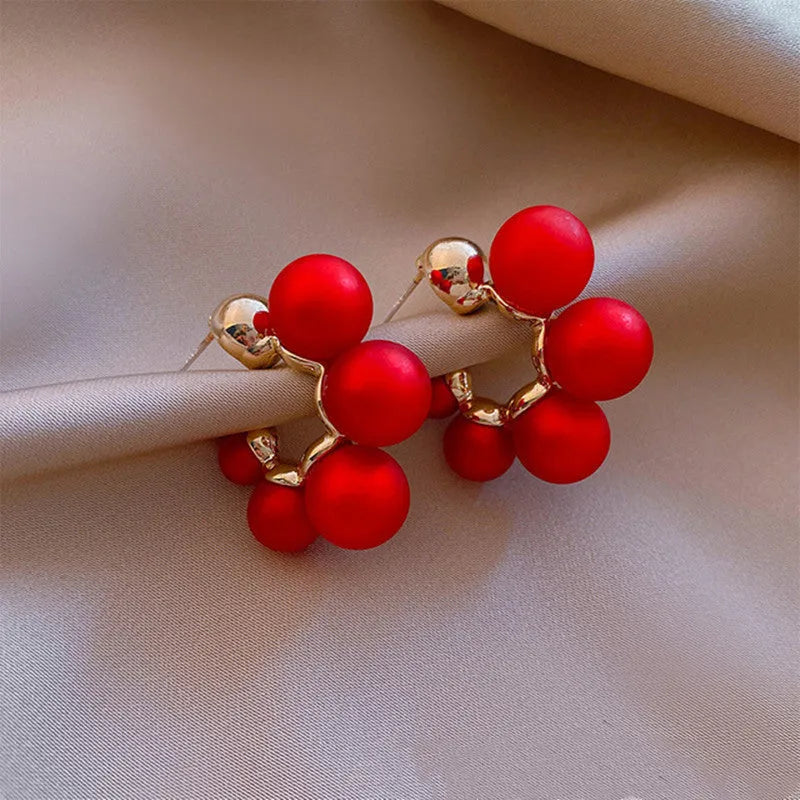 Close-up of red bell-shaped alloy drop earrings for women.