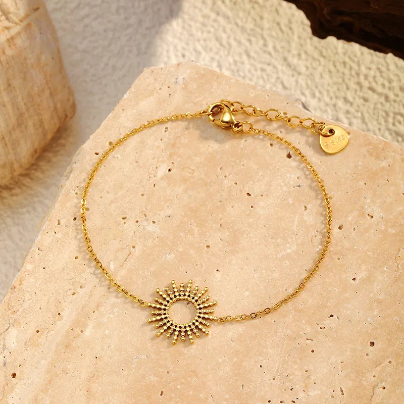 Gold-coloured SUNFLOWER Series necklace and bracelet set with chain links on a white background.