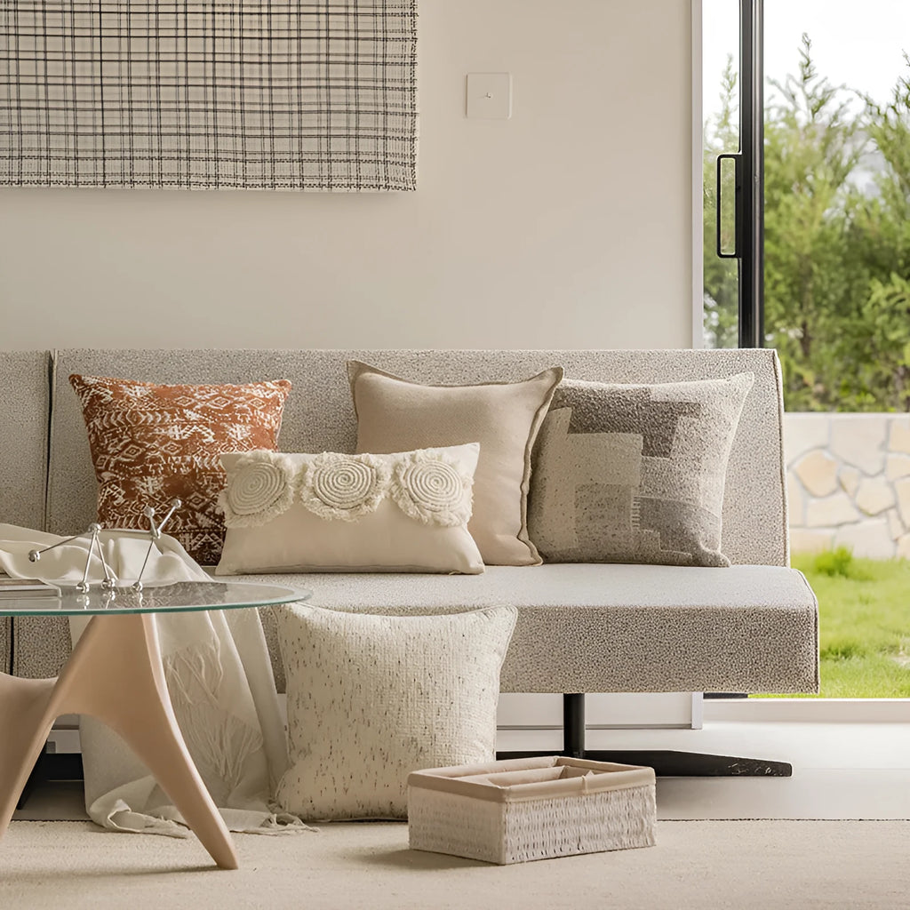 A square solid-colour cushion pillow on a sofa, showing its plain edge detail.