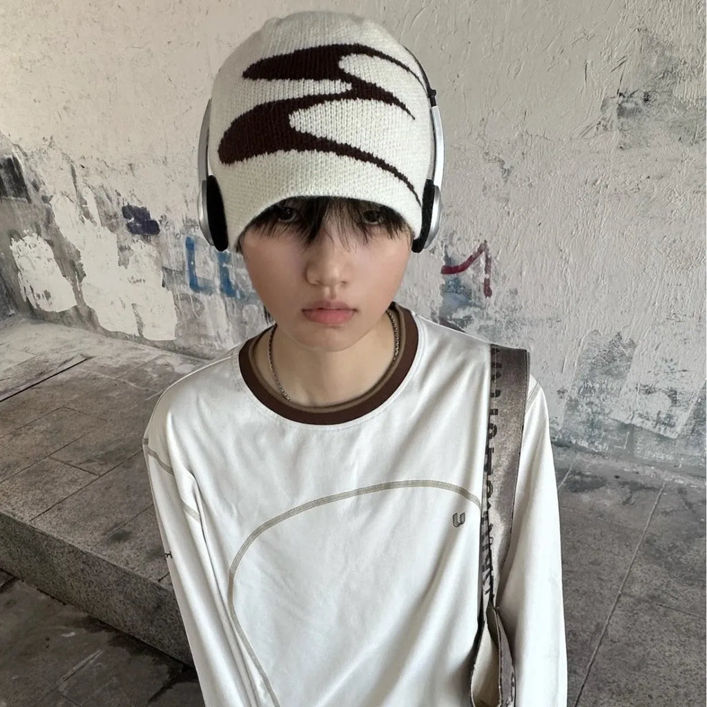 A knitted acrylic beanie hat in black, shown on a model, for autumn and winter wear.