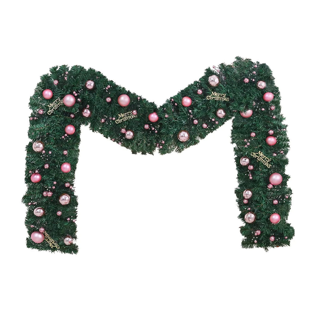Pink artificial rattan Christmas garland with small fruit and LED lights draped over a banister