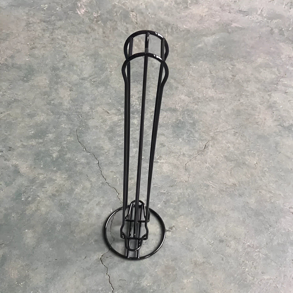 Black wrought iron coffee capsule storage rack holding 20 pods on a kitchen counter.