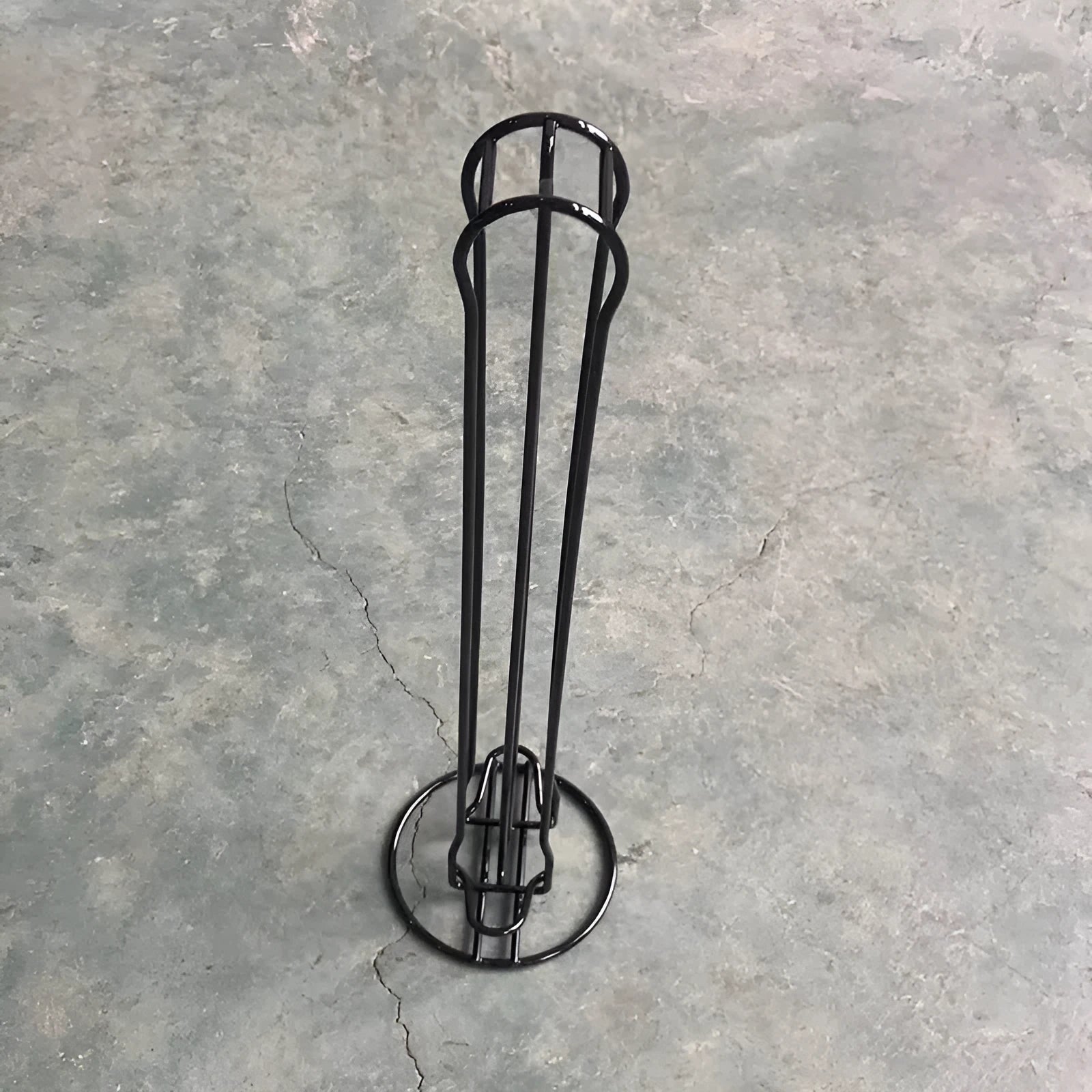 Black wrought iron coffee capsule storage rack holding 20 pods on a kitchen counter.