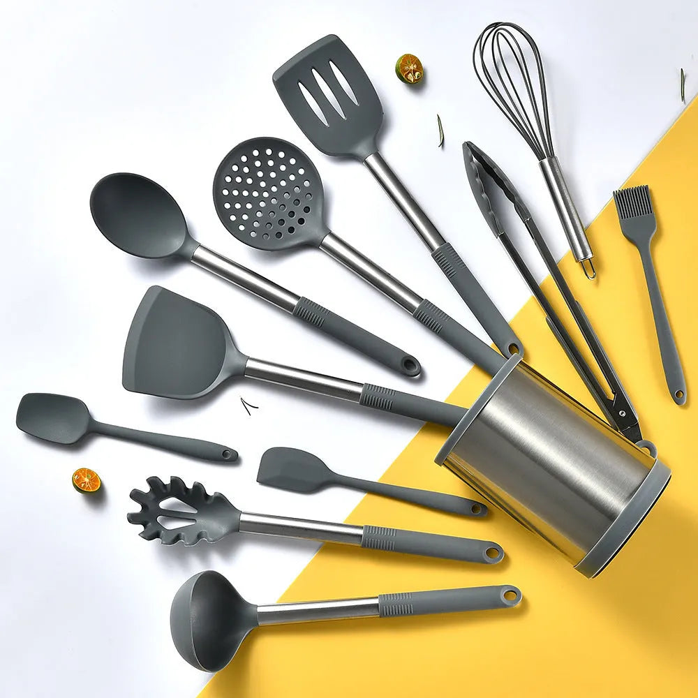 Black silicone kitchen utensil set with 12 tools stored in a rotating plastic storage bucket on a worktop.