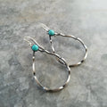 A pair of antique silver geometric circle earrings with a turquoise blue centre, showing bohemian vintage style.