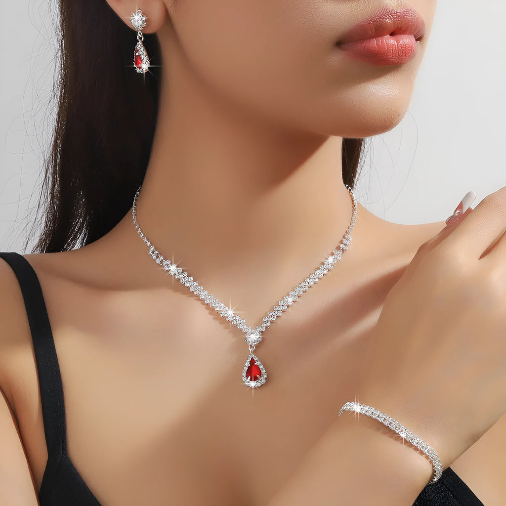 Women's blue claw chain necklace and drop rhinestone earrings set on white background.