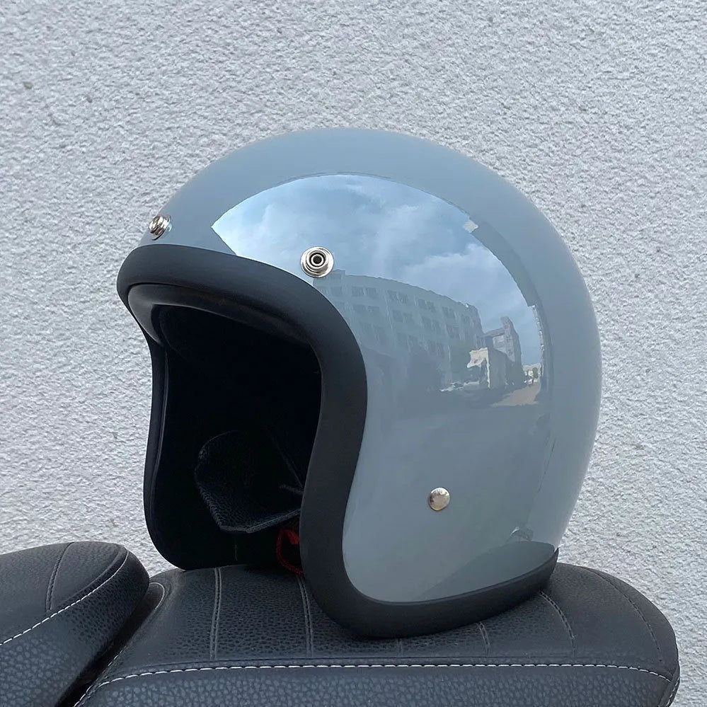Retro-style motorcycle half helmet in cement grey with a glossy fibreglass shell on a plain background.