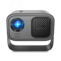 Black portable smart HD projector with remote control on a desk.
