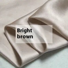 Double-sided solid colour silk duvet cover in bright brown laid flat on a bed.