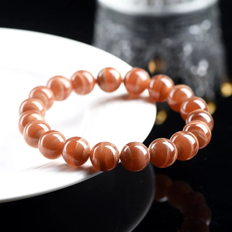 Natural Old Mine Rhodochrosite round bead bracelet with Ruyi design, shown in 6mm and 8mm sizes.