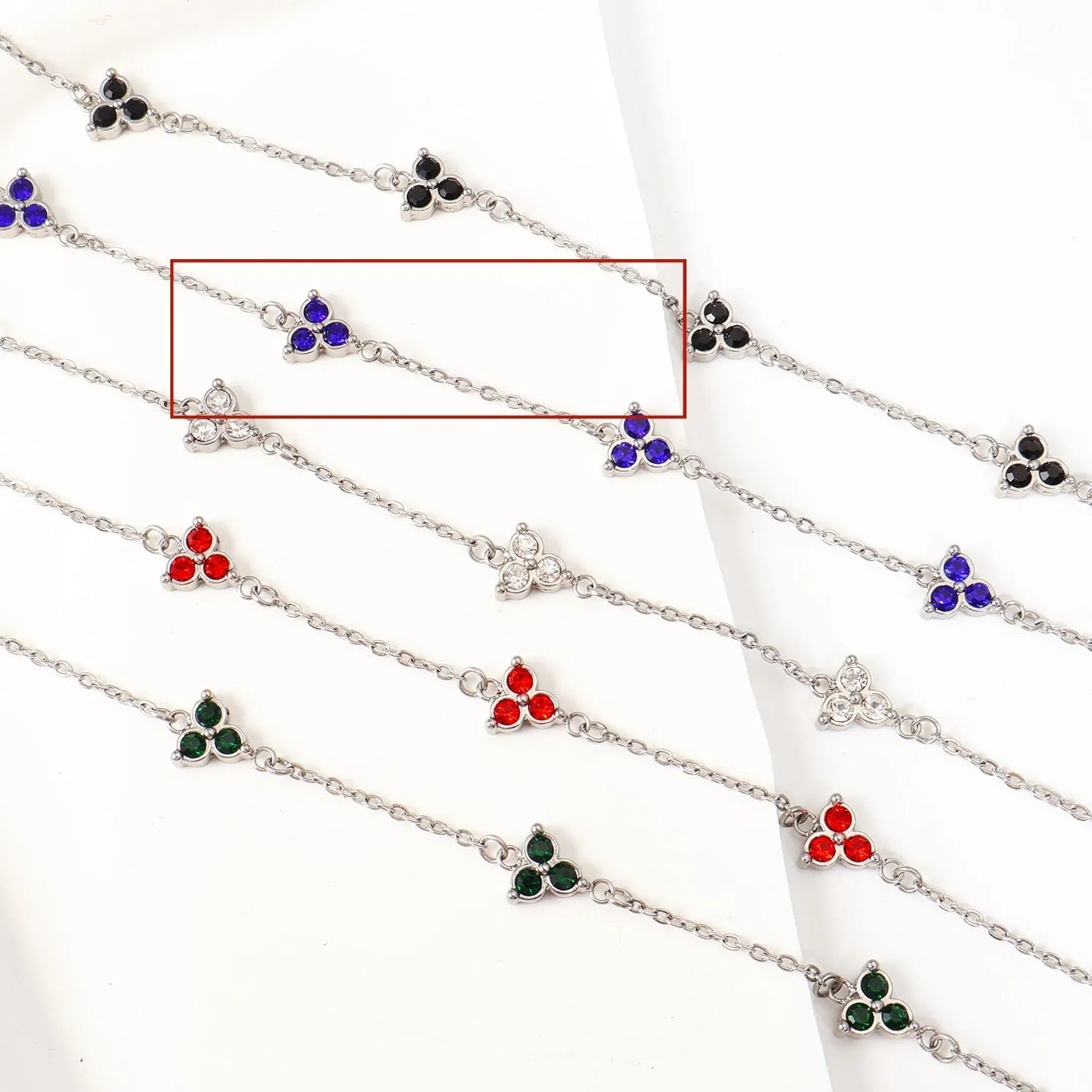 Geometric stainless steel women's bracelet with triangular links and a coloured stone centre.