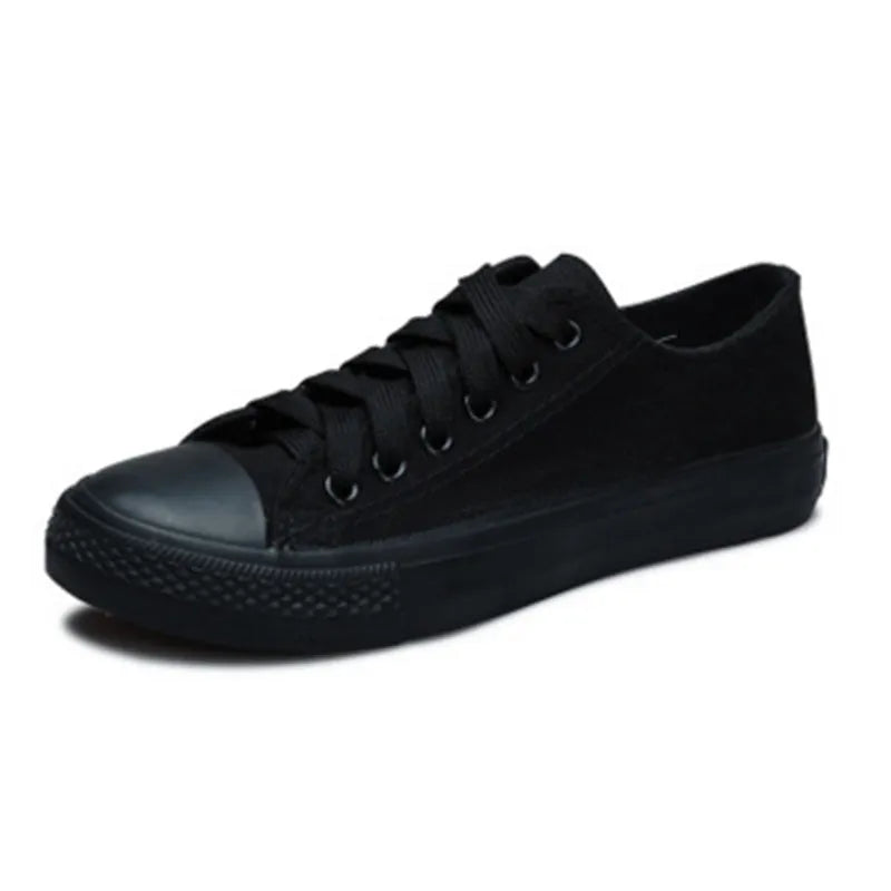 A pair of solid colour canvas lace-up trainers for women on a summer background.