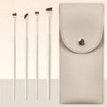 Four angled eyeliner and brow brushes with fine bristles in a leather makeup case