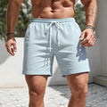 Man wearing loose-fitting solid colour polyester track shorts in a casual setting.