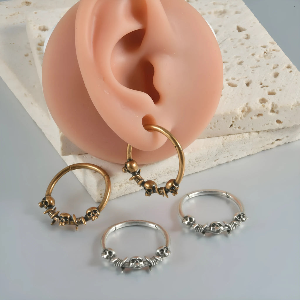 Close-up of vintage-style copper stud earrings featuring a detailed stamped ghost head motif with an antique silver finish.