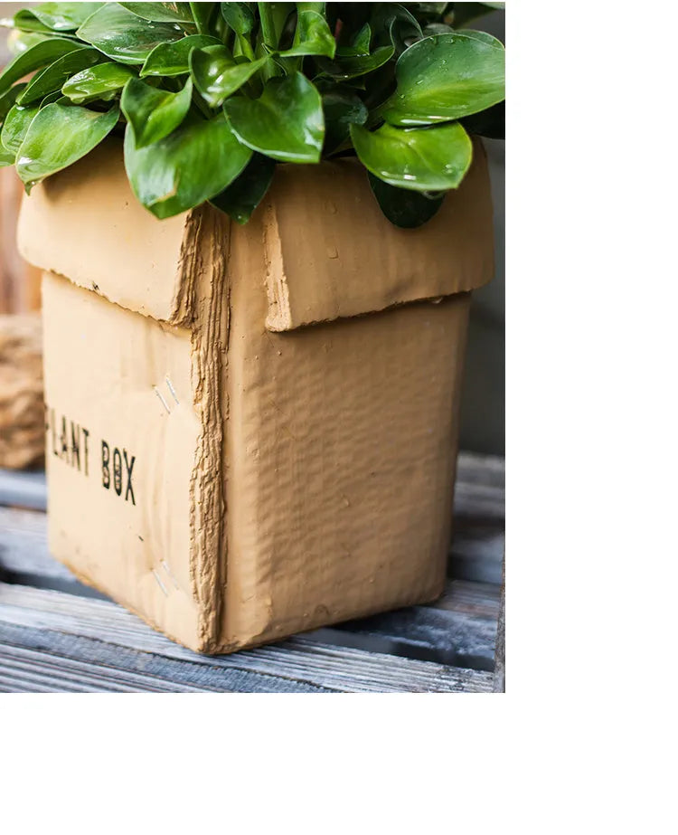 Cement flower pot with brown paper box design showing perforated drainage base