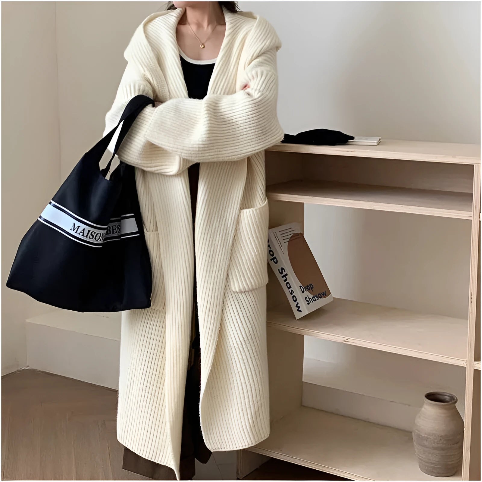 Women's loose grey hooded cardigan coat with raglan sleeves on a hanger.