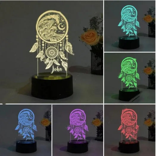 Black base dream catcher night light with acrylic shade and remote control on a table.