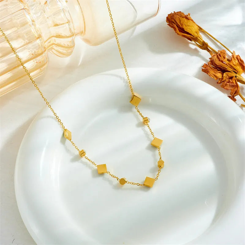 Gold titanium steel necklace with U-shaped pendant, square emerald zircon, and cross chain, 41-50cm.