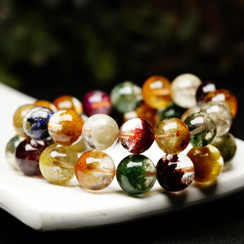 Colourful ghost cornucopia crystal bracelet with 10mm beads on a wrist.