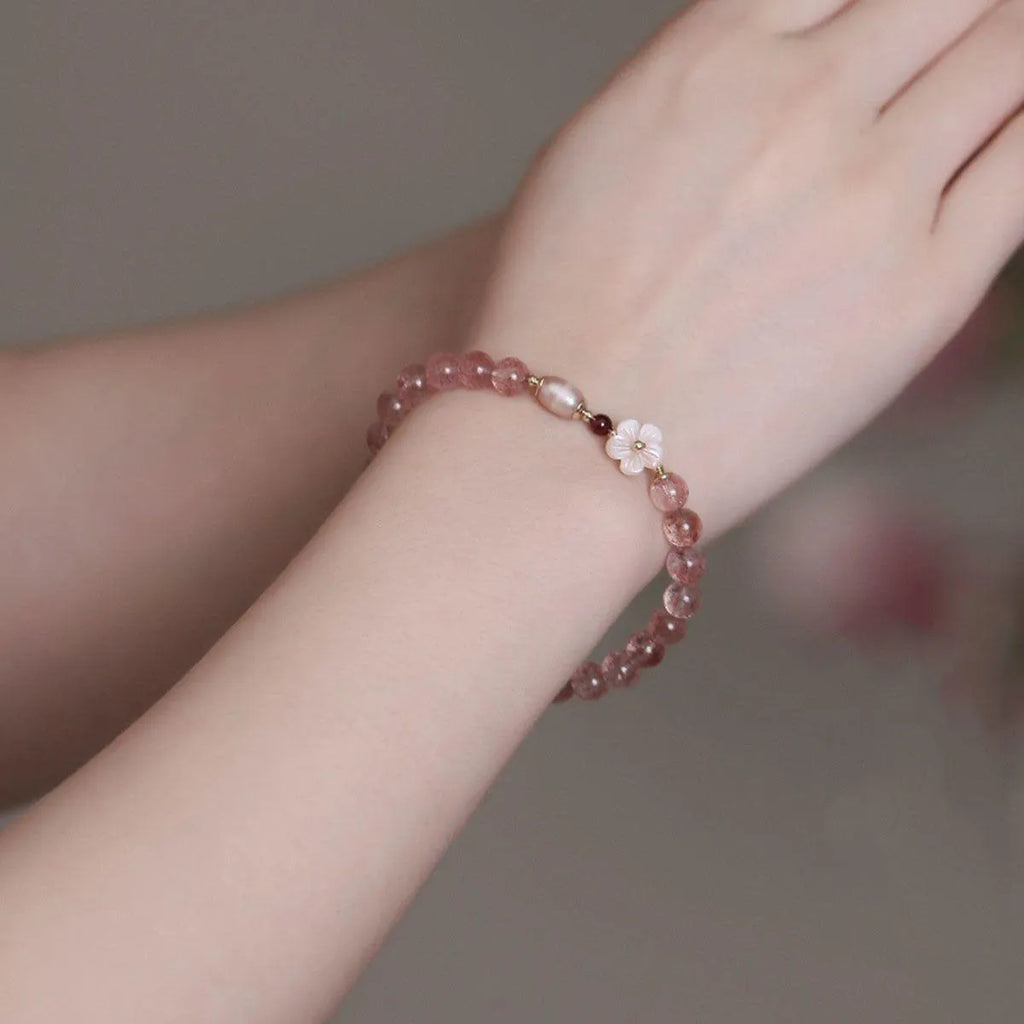 Light pink strawberry quartz crystal bracelet with peach blossom floral design and adjustable fastening