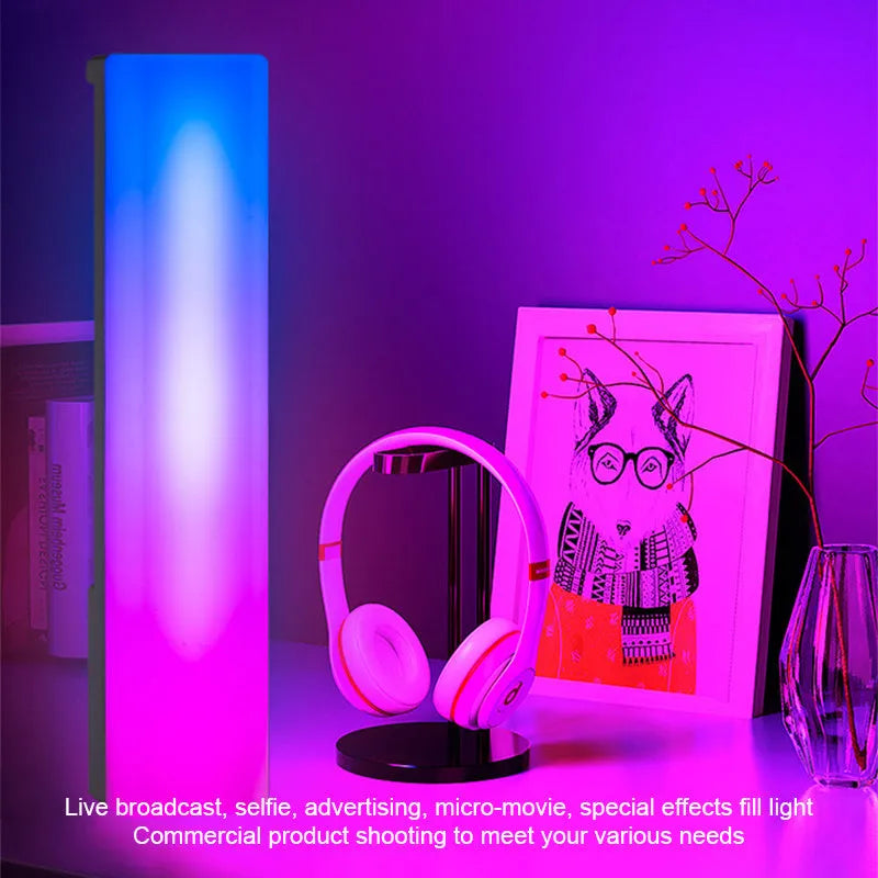 A tall, colourful RGB table lamp with a white or black shell reacting to sound on a desk.