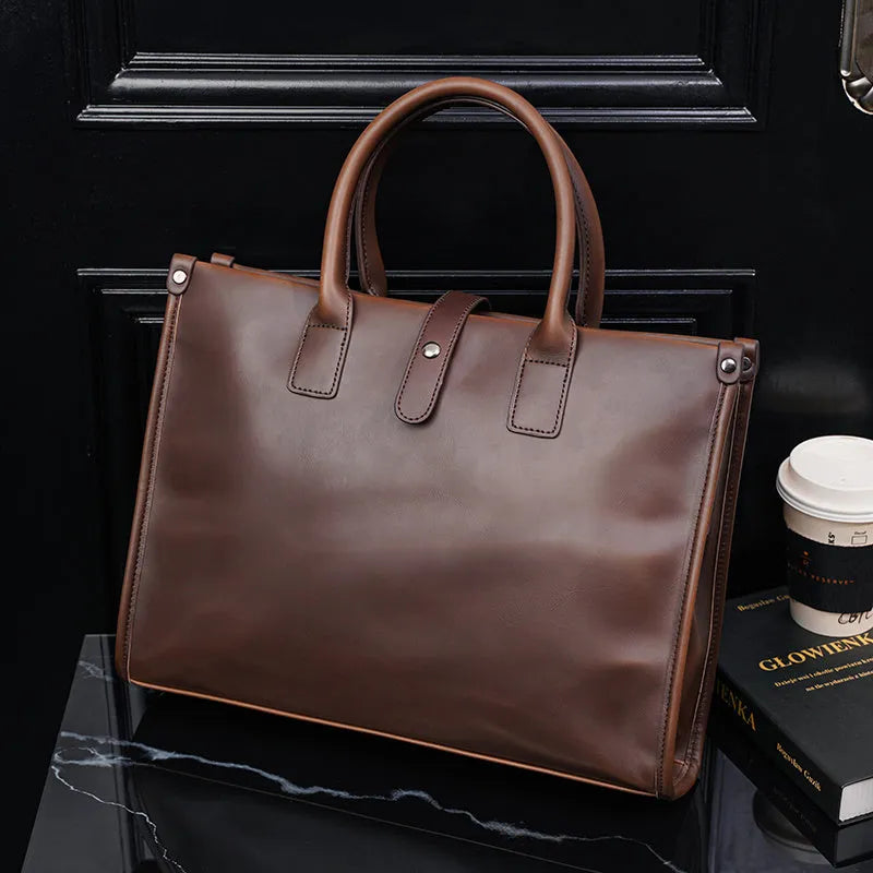 Brown men's messenger bag with soft PU surface and multiple compartments on a flat surface