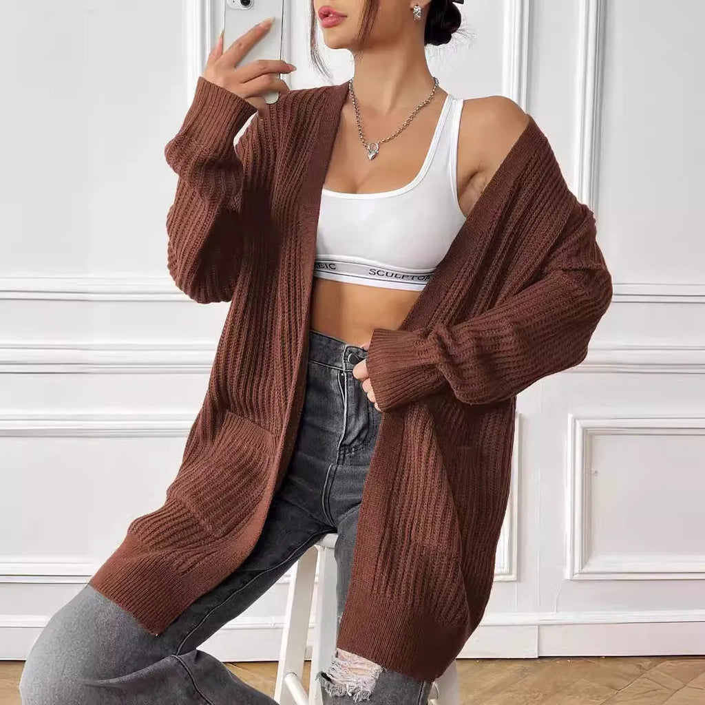 Women's dark green loose-fit acrylic knit cardigan with long sleeves on a hanger.