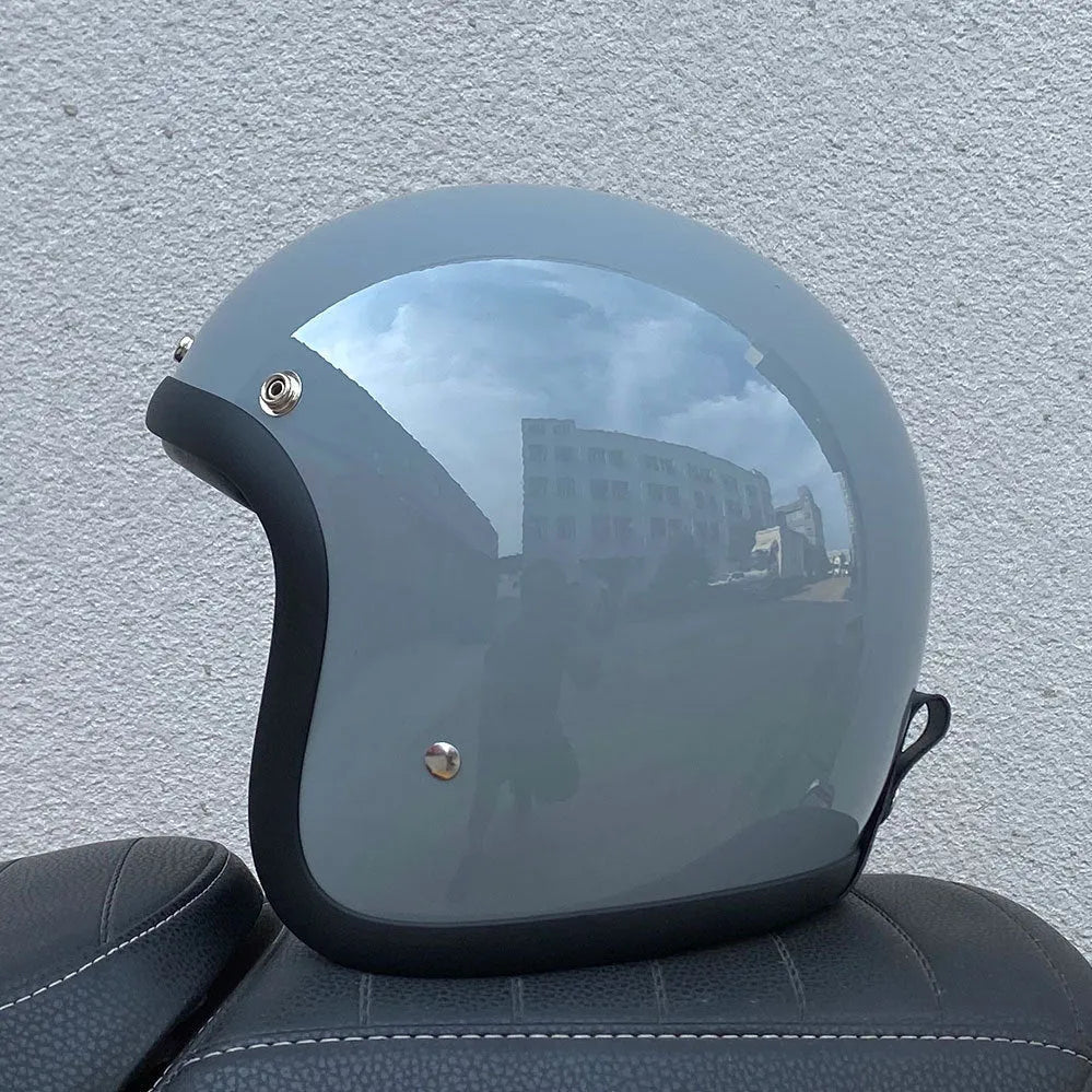 Retro-style motorcycle half helmet in cement grey with a glossy fibreglass shell on a plain background.