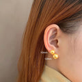 Large geometric pearl stud earrings for women with an eight-point star detail on a silver setting.