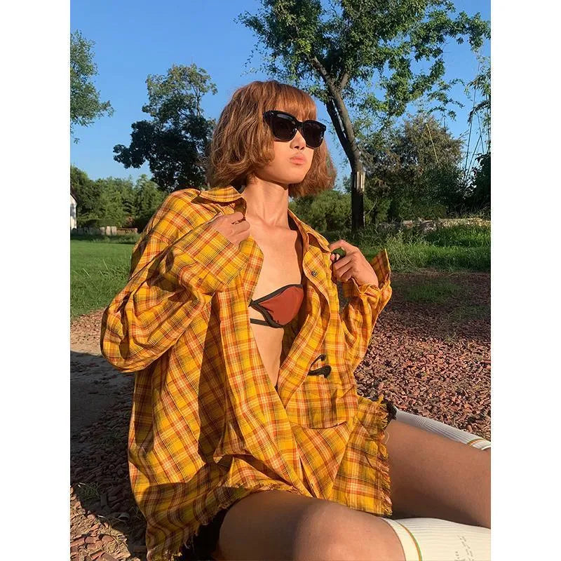 A loose-fit yellow plaid cardigan shirt for men and women, shown on a hanger.