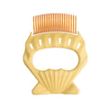 Shell-shaped plastic pet grooming brush with bent wire bristles in green, orange, or purple colours