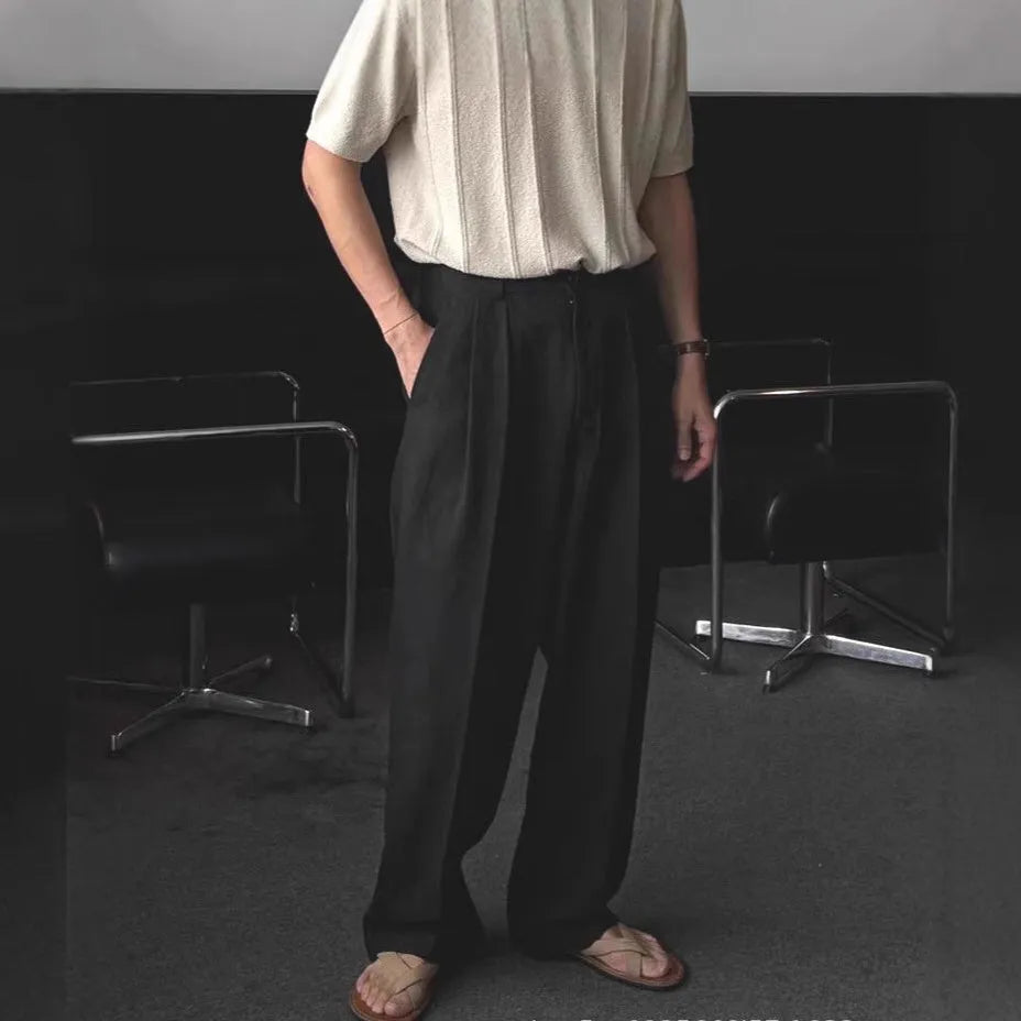 Men's apricot coloured wide-leg cotton linen trousers with a mid waist and zip fly on a neutral background.