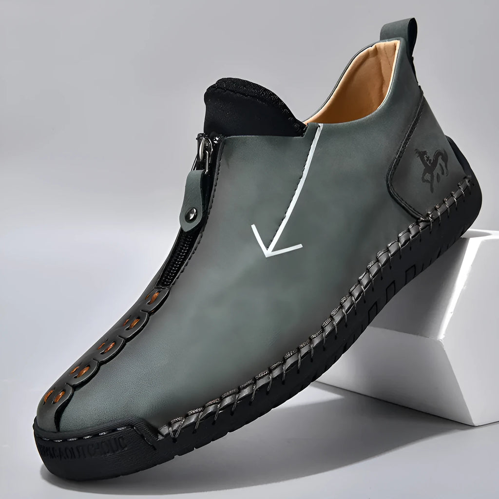 Men's black leather casual boot with front zip, round toe, and rubber sole on a white background.
