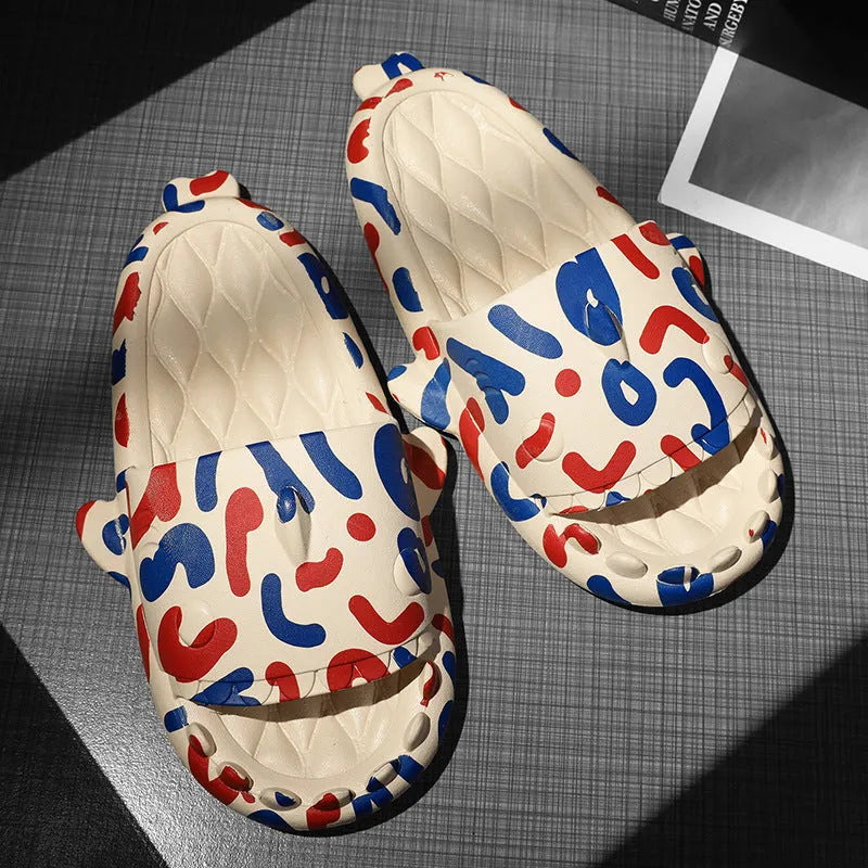 Pair of grey open-toe EVA slippers with raised shark design on the front, shown on a wooden floor.
