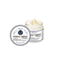 60g glass jar of cow fat moisturising cream with honey and vitamins on a plain background
