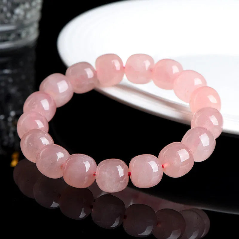 Pink natural crystal bracelet with 8x10mm barrel-shaped beads on a cord.