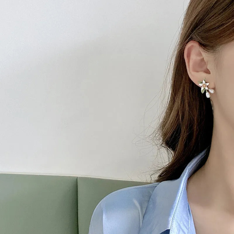 A pair of alloy flower earrings for women, showing sterling silver needle flower studs and a matching flower clip-on style.