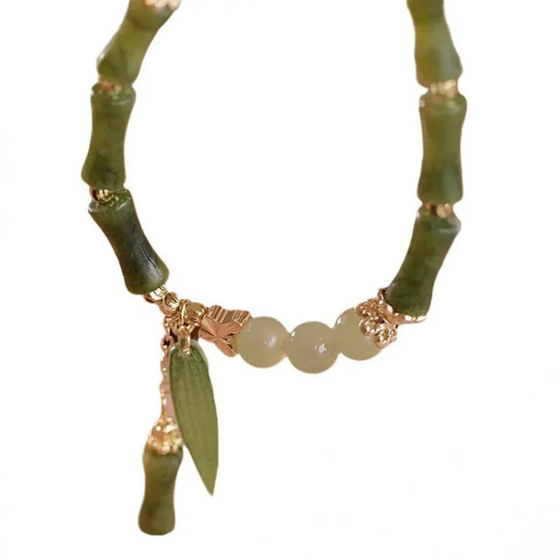 Chinese style glass bracelet with bamboo leaf design on wrist.