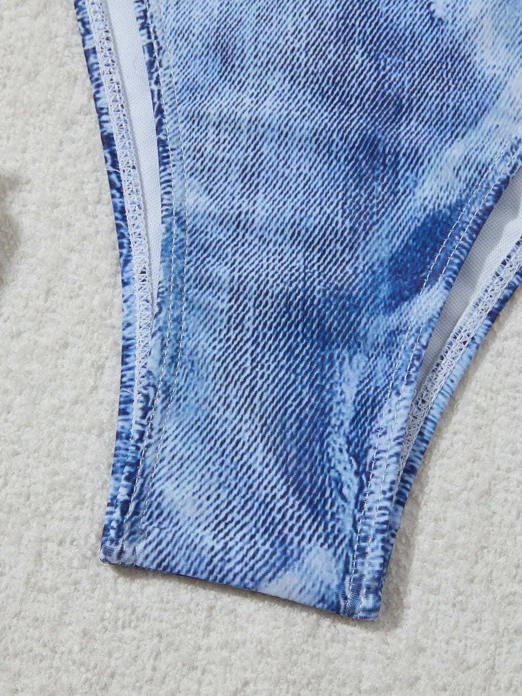 Women's denim blue printed bikini set with strap design on a hanger.