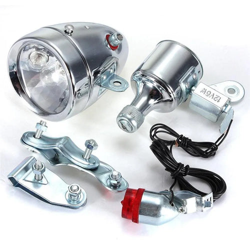 Silver bicycle dynamo generator light kit mounted on a bike fork, with wires for headlight and tail light connections.